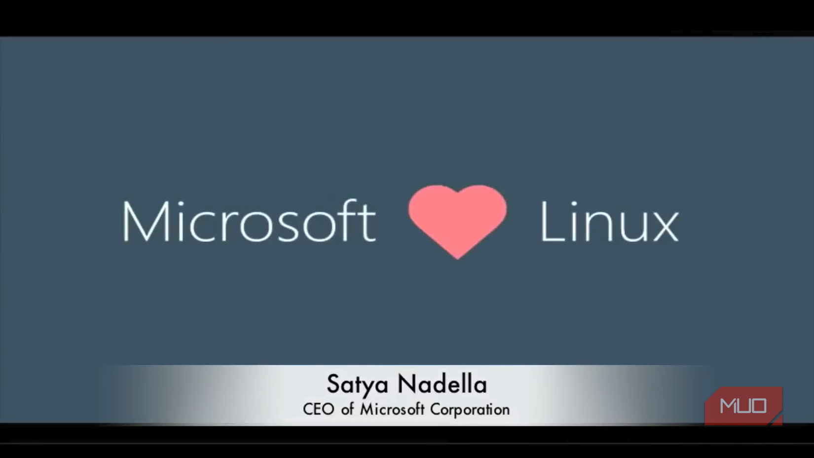 Satya Nadella presentation slide displaying the phrase Microsoft [pink heart icon] Linux.