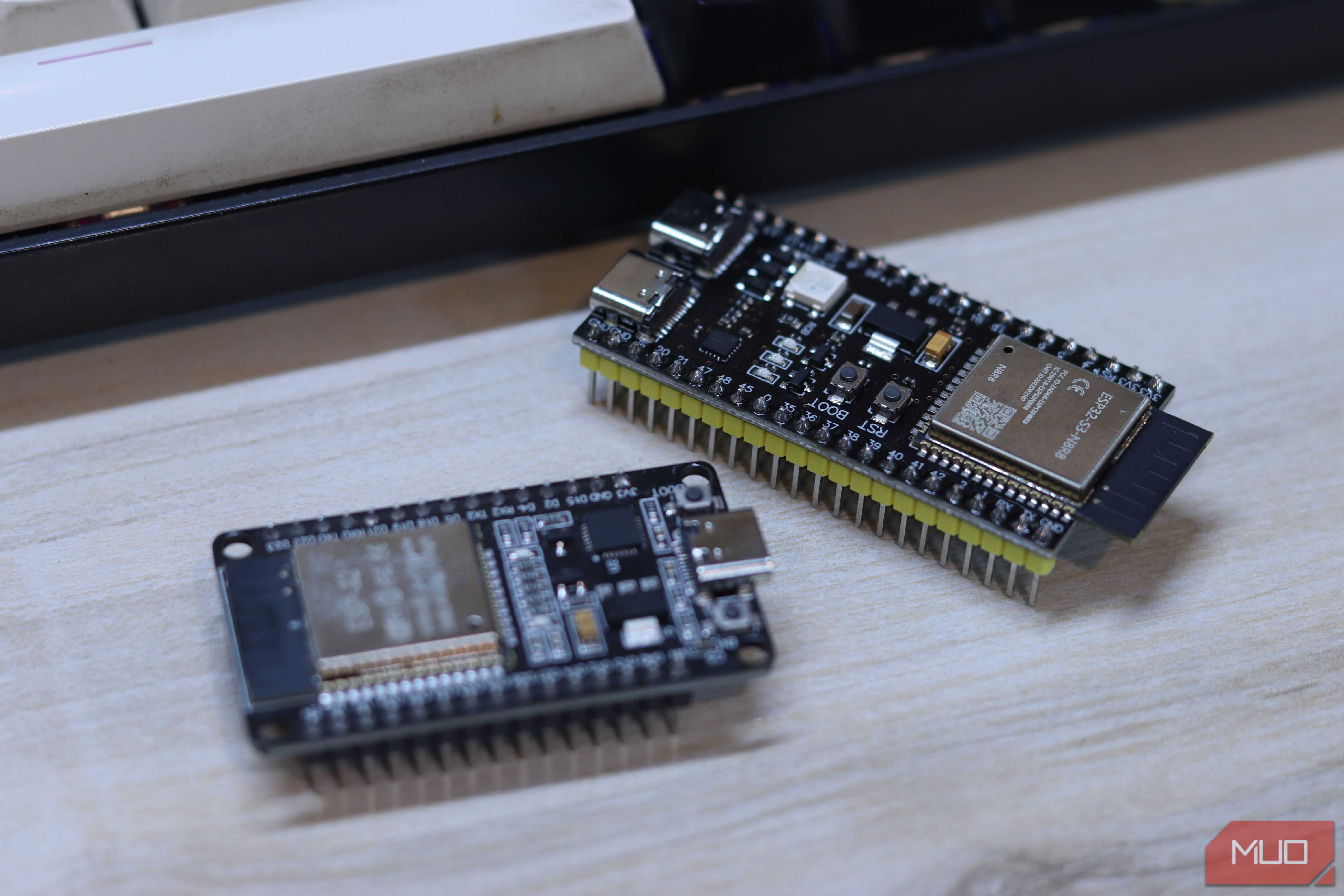 Two ESP32 boards, classic and S3, side by side on a wooden desk