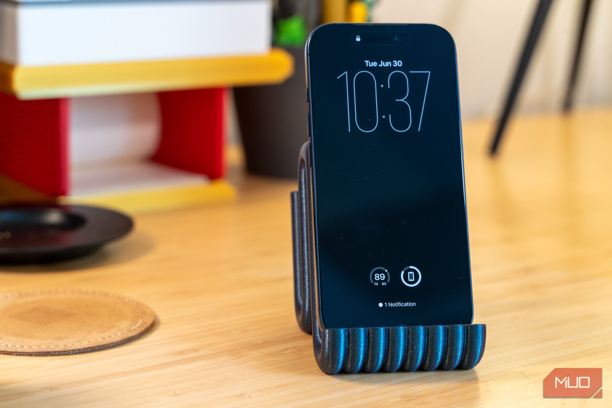 3D printed phone holder with iPhone front view on desk.