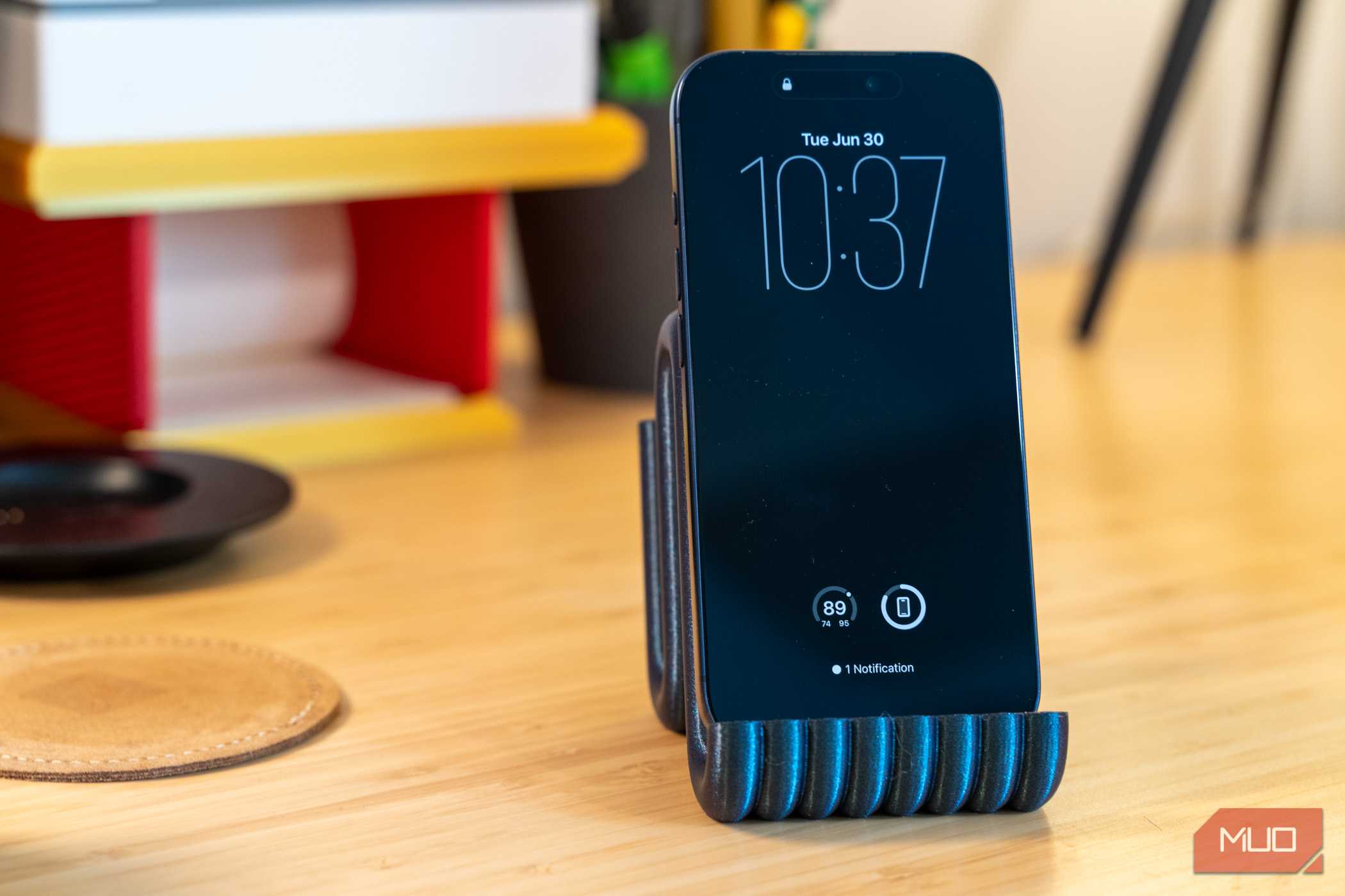 3D printed phone holder with iPhone front view on desk.