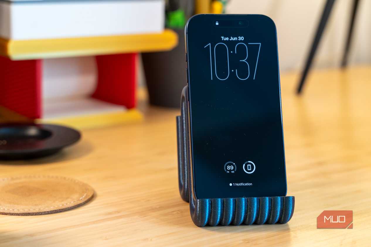 3D printed phone holder with iPhone front view on desk.