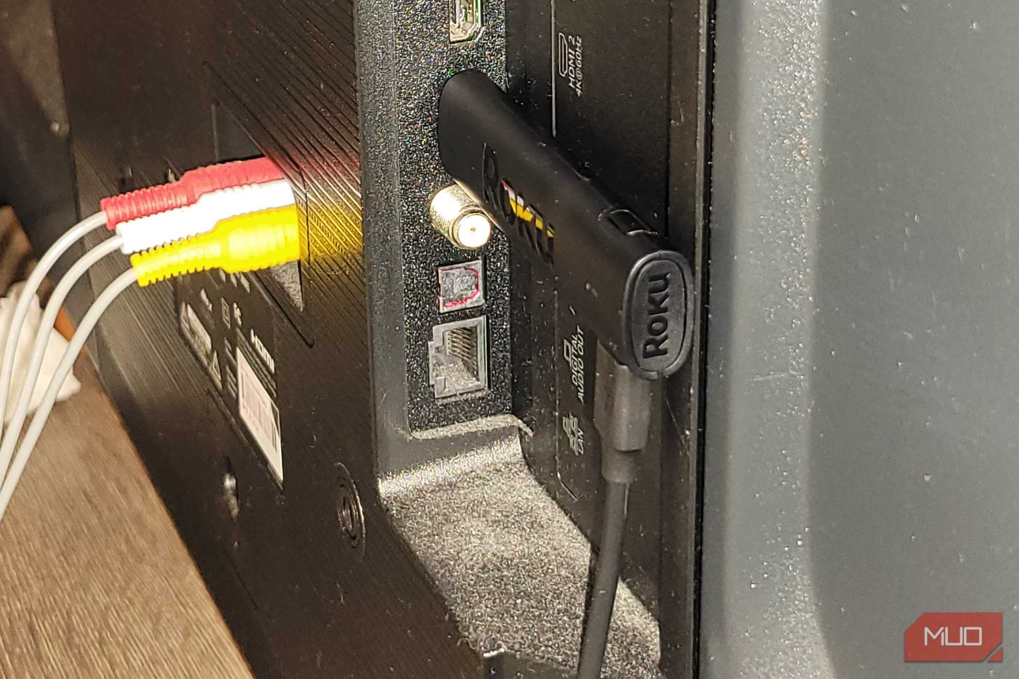 A roku stick on the back of a TV