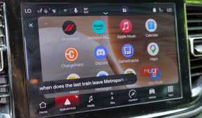 Asking Gemini for train information while driving with Android Auto.