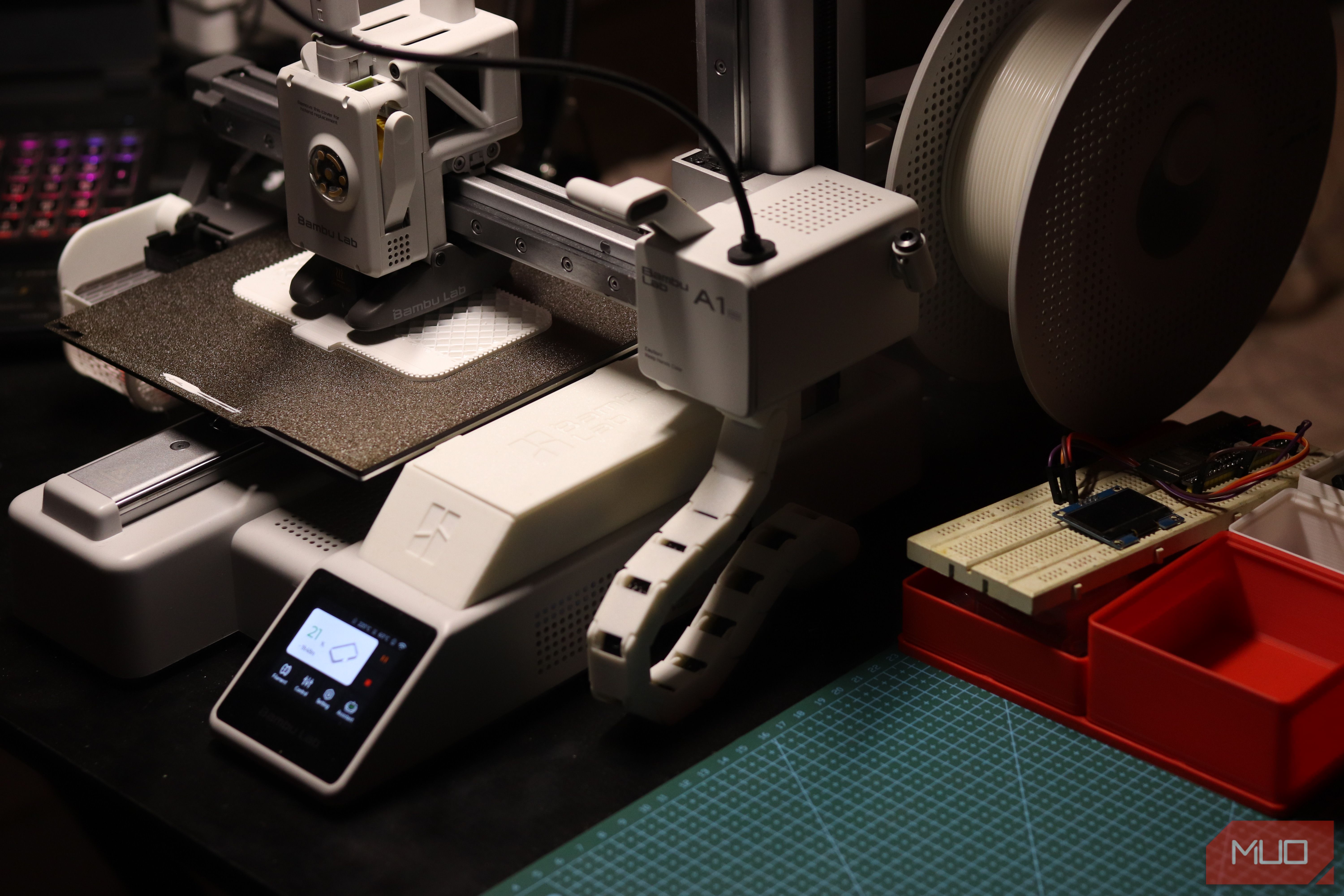 Bambu Labs A1 Mini next to cutting mat.