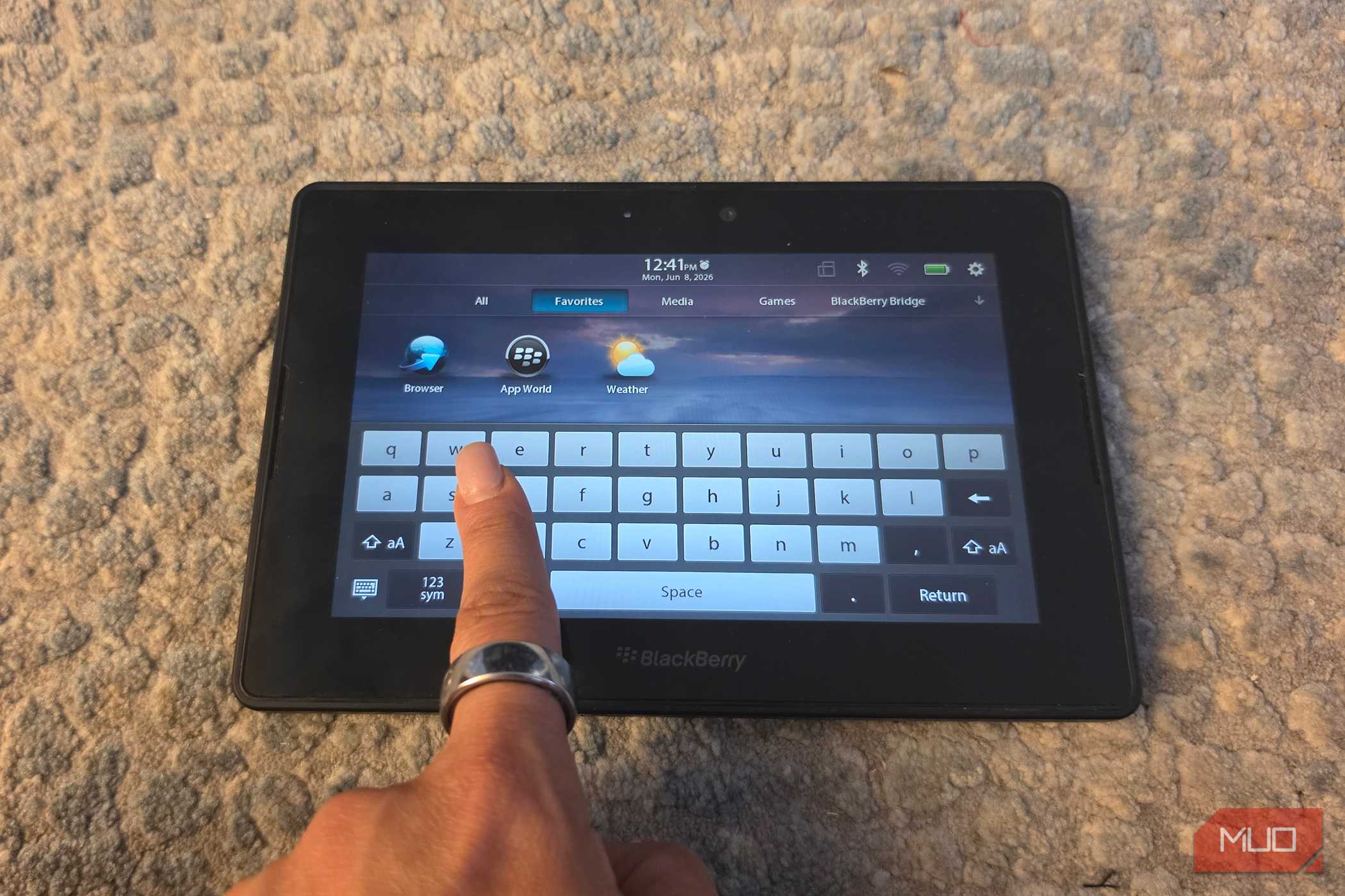 A finger pulling up the virtual keyboard on a BlackBerry PlayBook