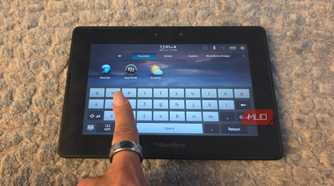 A finger pulling up the virtual keyboard on a BlackBerry PlayBook