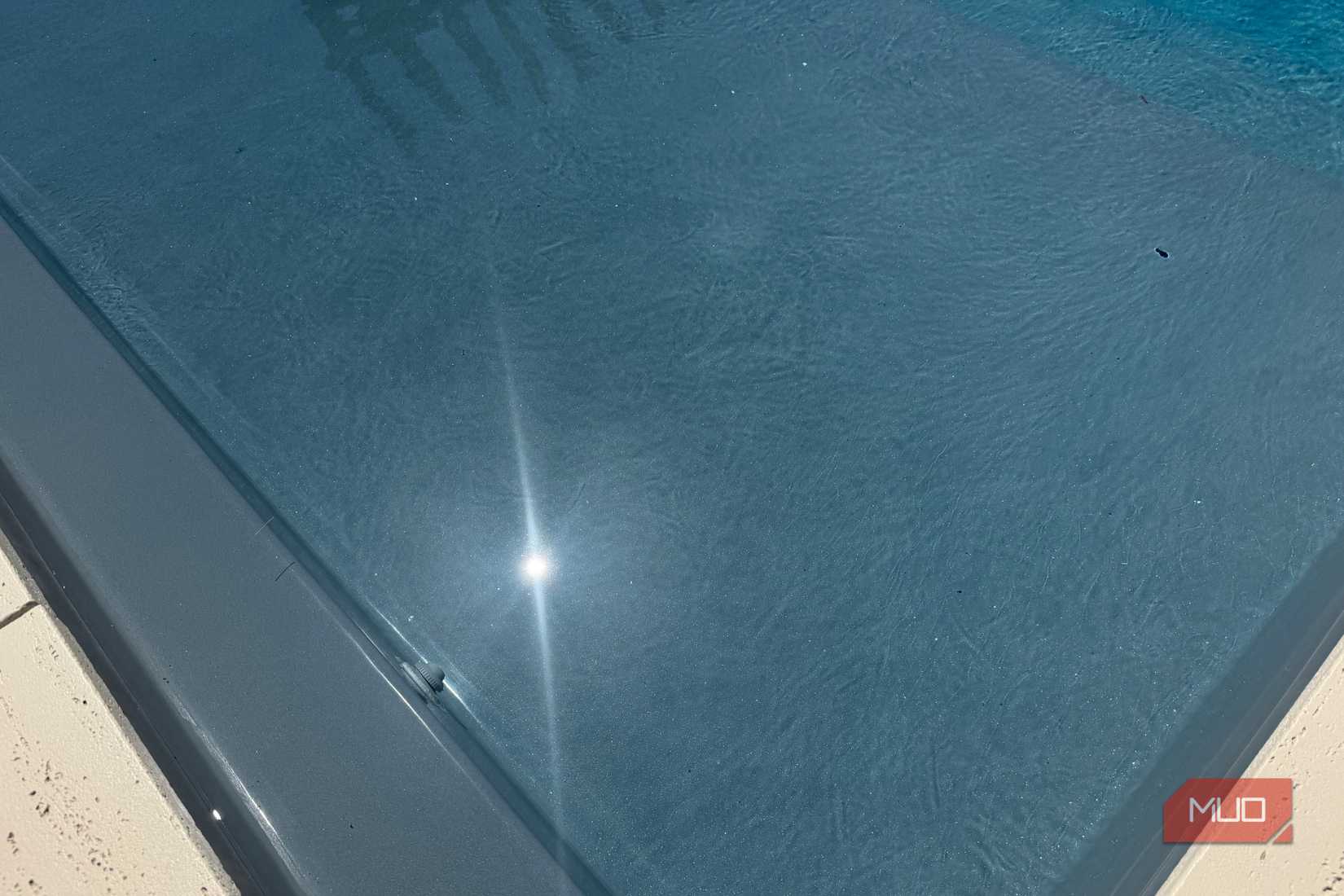 close up of pool water with sun reflection