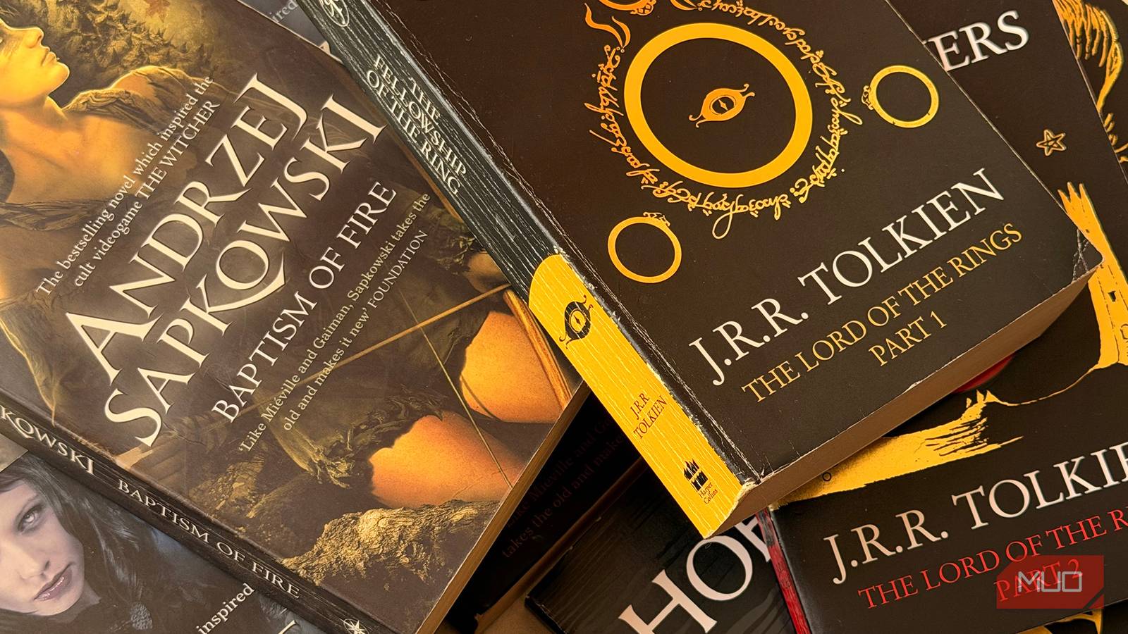 Fantasy books including the Wticher series and The Lord of the Rings spread on a table