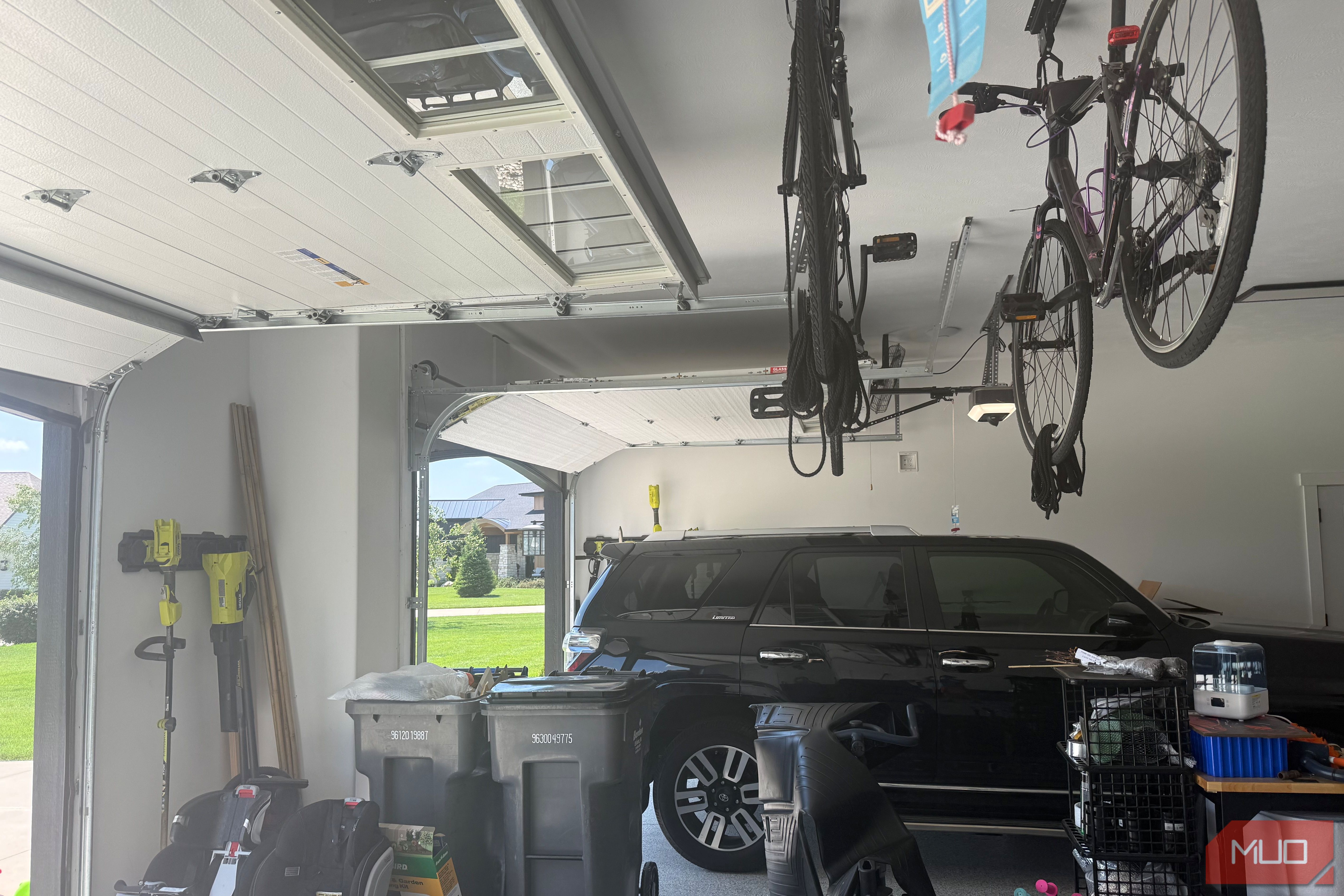 garage interior with black suv and ceiling mounted bikes