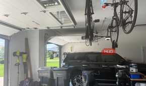 garage interior with black suv and ceiling mounted bikes