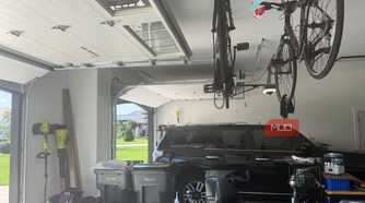 garage interior with black suv and ceiling mounted bikes