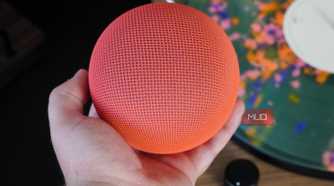 Holding the Google Home Speaker in the hand.