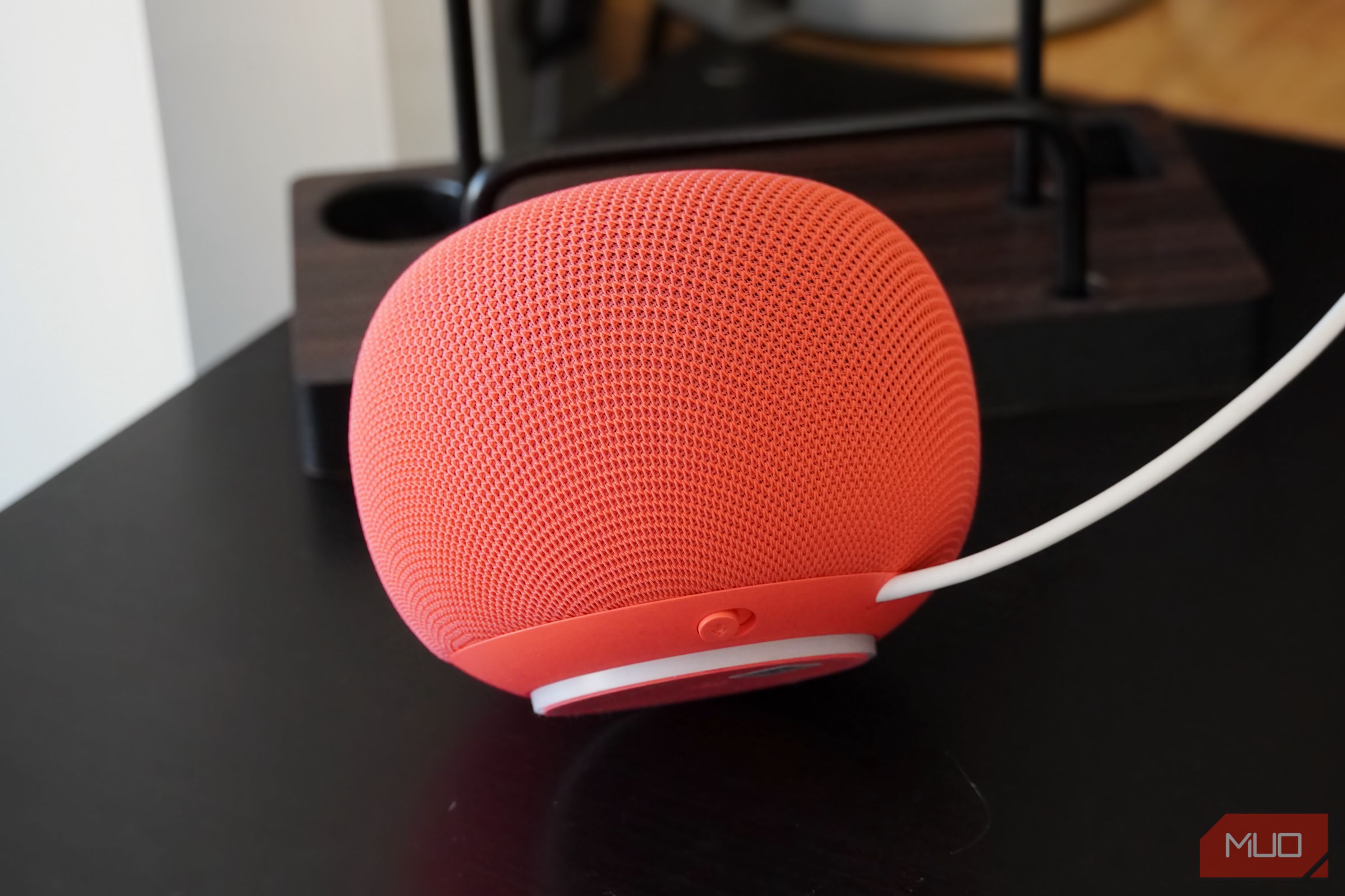 A titled view of the Home Speaker showing the mute switch and glow ring.