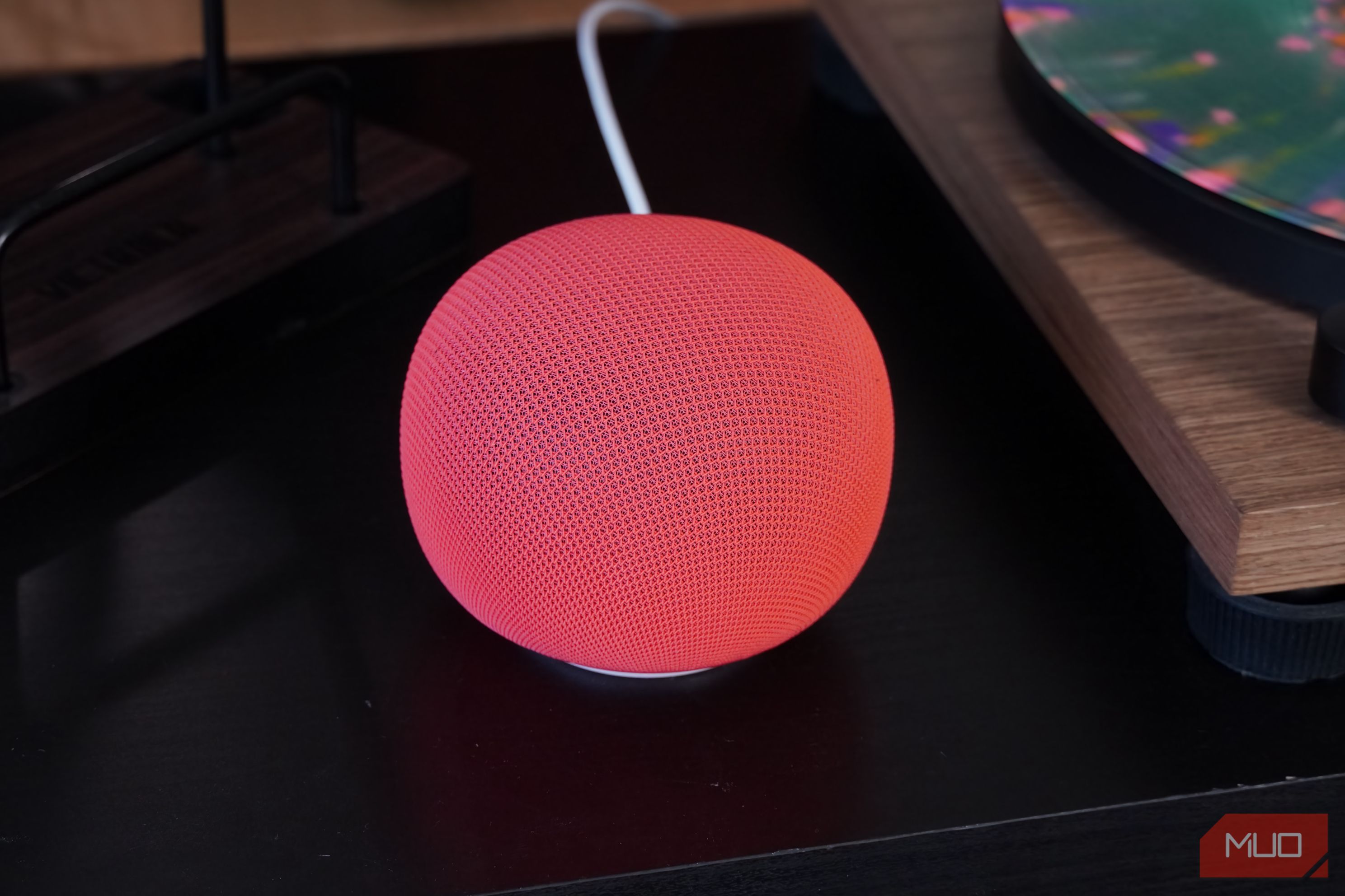 The Google Home Speaker on a black table.