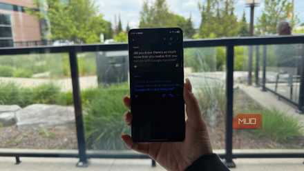 A hand holding a phone by a window showing Google Translate.