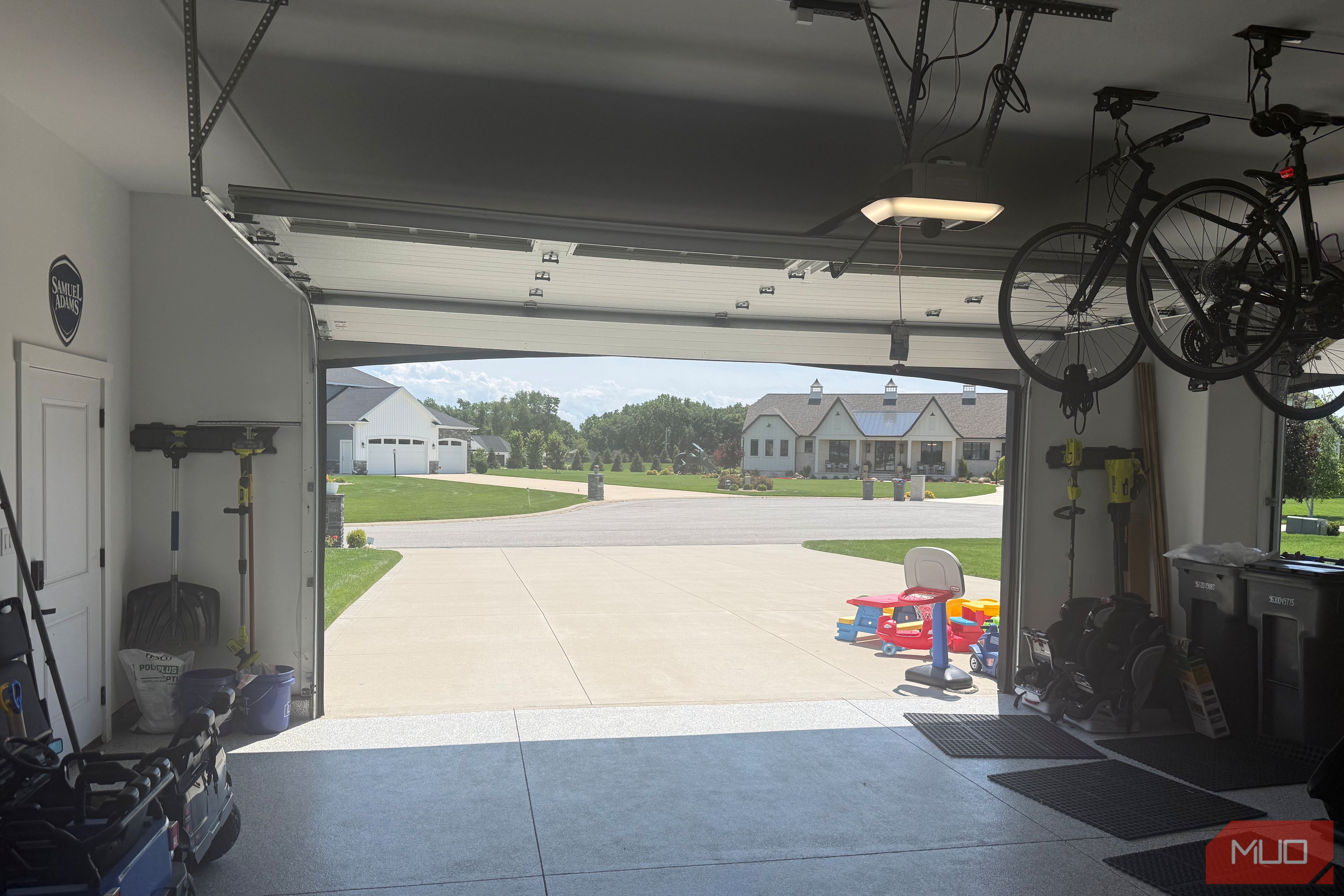 interior garage looking out open door with ceiling bikes and kids toys