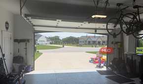 interior garage looking out open door with ceiling bikes and kids toys