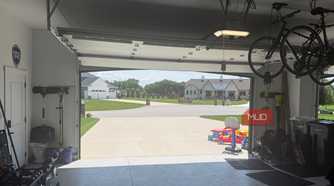 interior garage looking out open door with ceiling bikes and kids toys