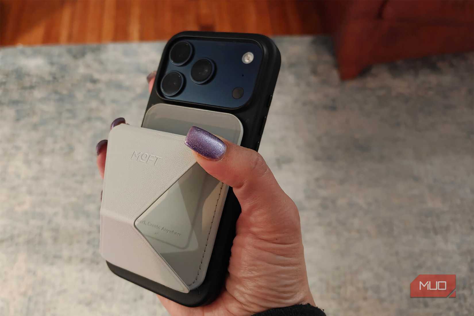 片手でiPhoneを持ち、背面にMOFTウォレットスタンドを取り付けます。