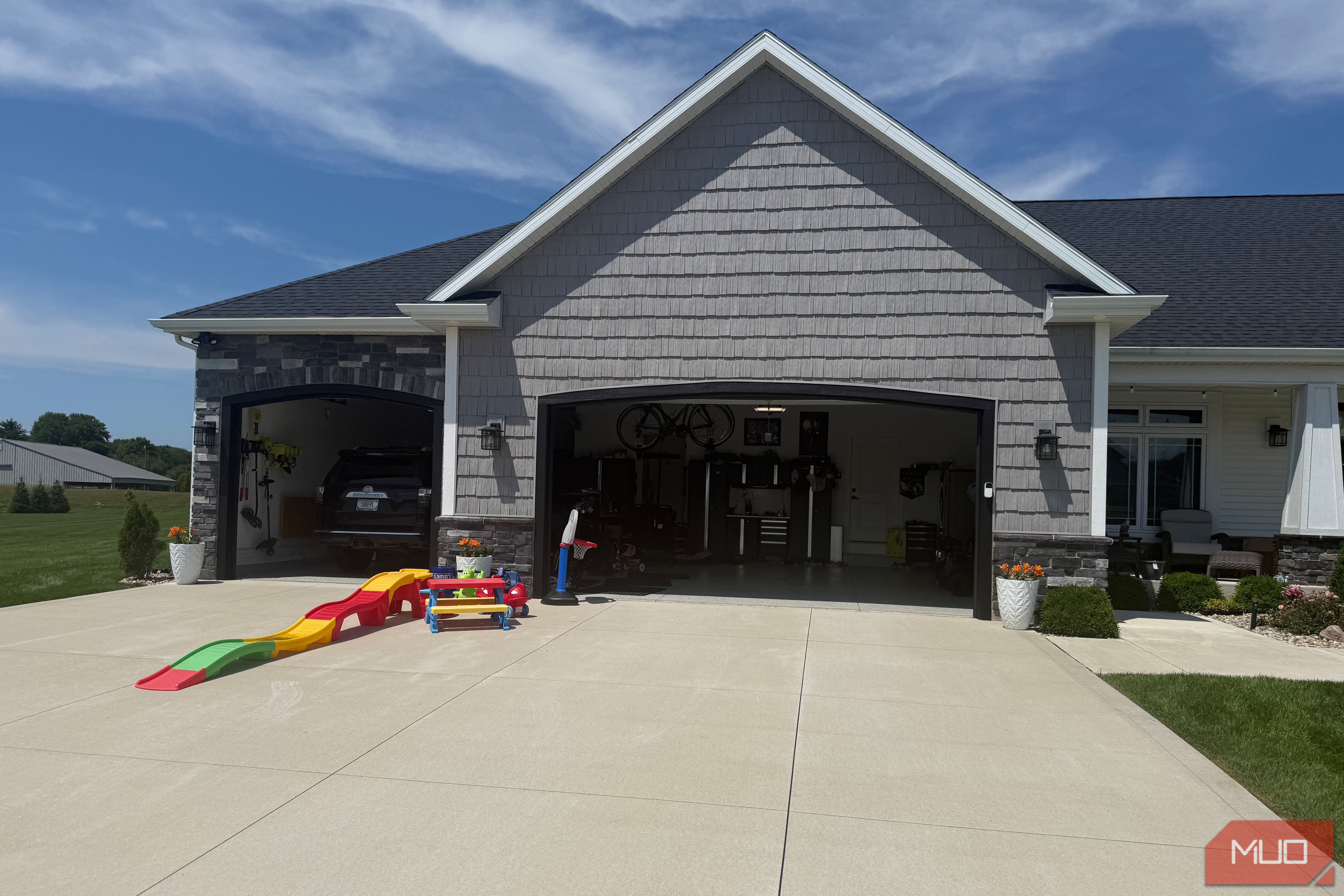 open garage with black suv inside and toddler slide in driveway
