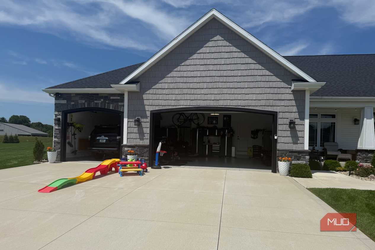 open garage with black suv inside and toddler slide in driveway