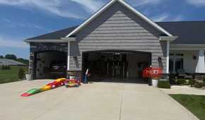 open garage with black suv inside and toddler slide in driveway