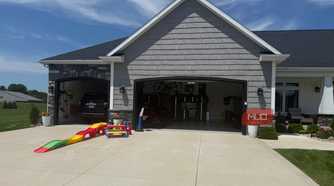 open garage with black suv inside and toddler slide in driveway