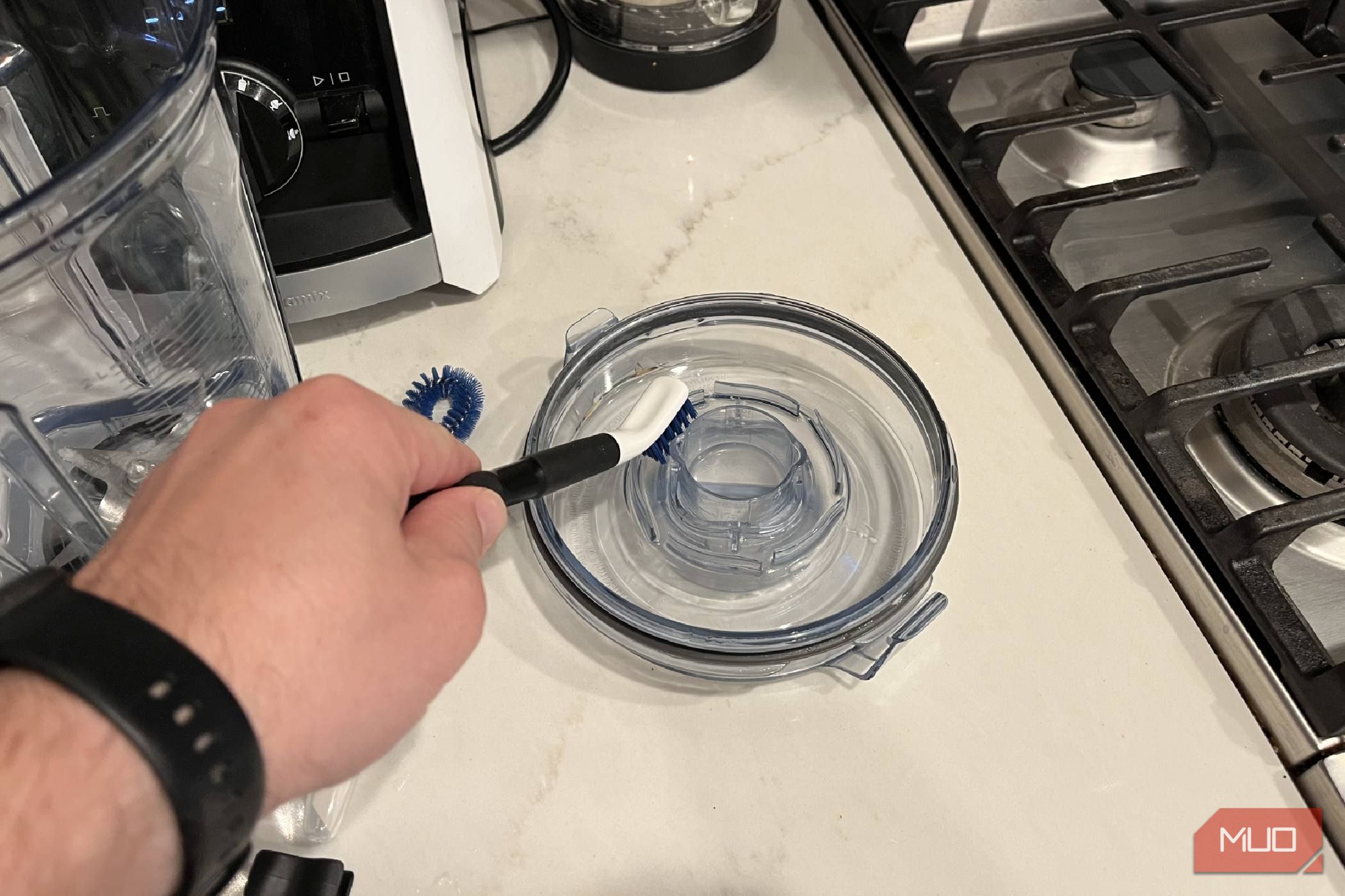 The OXO Good Grips Kitchen Appliance Cleaning Set cleaning a lid.