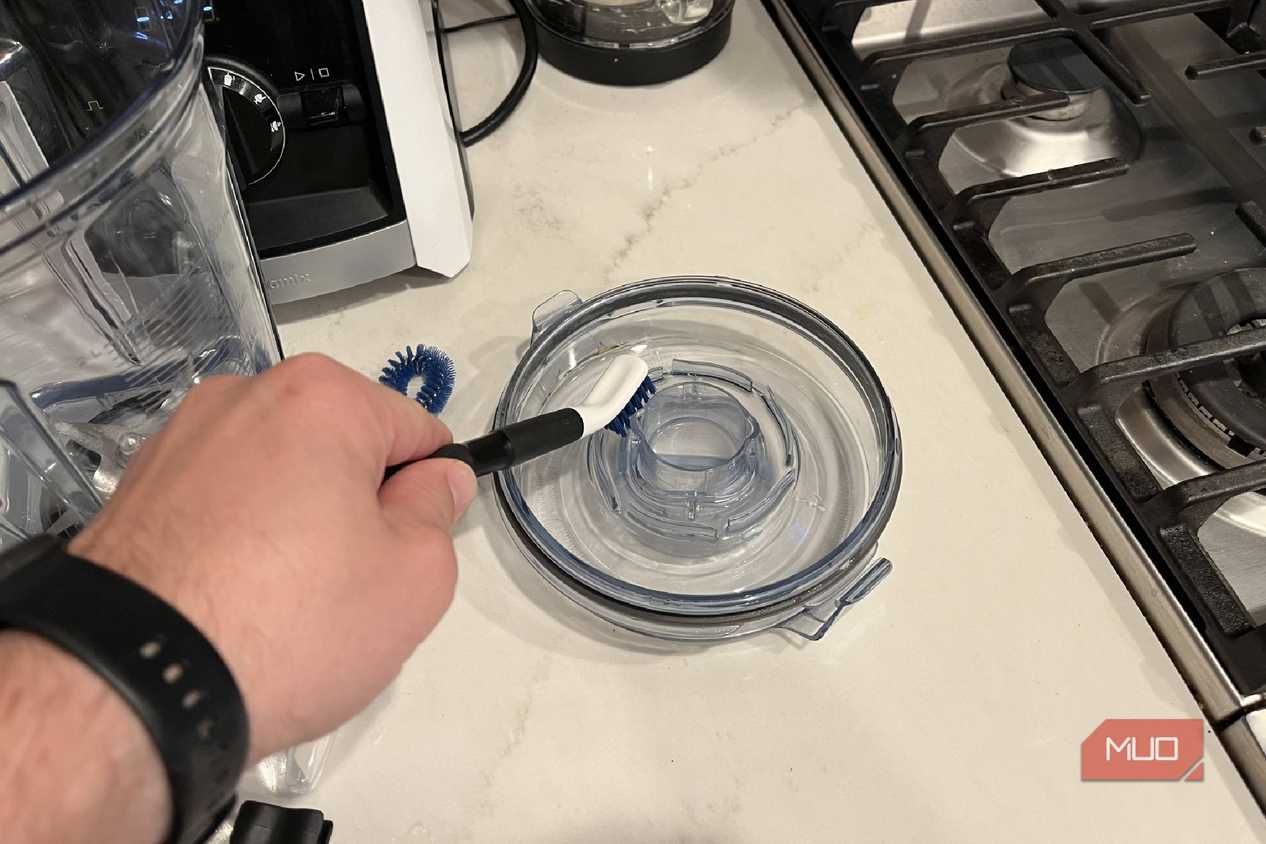 The OXO Good Grips Kitchen Appliance Cleaning Set cleaning a lid.