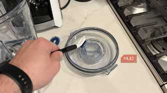 The OXO Good Grips Kitchen Appliance Cleaning Set cleaning a lid.