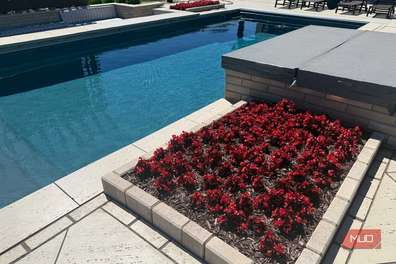 pool with red flower planter and spa cover