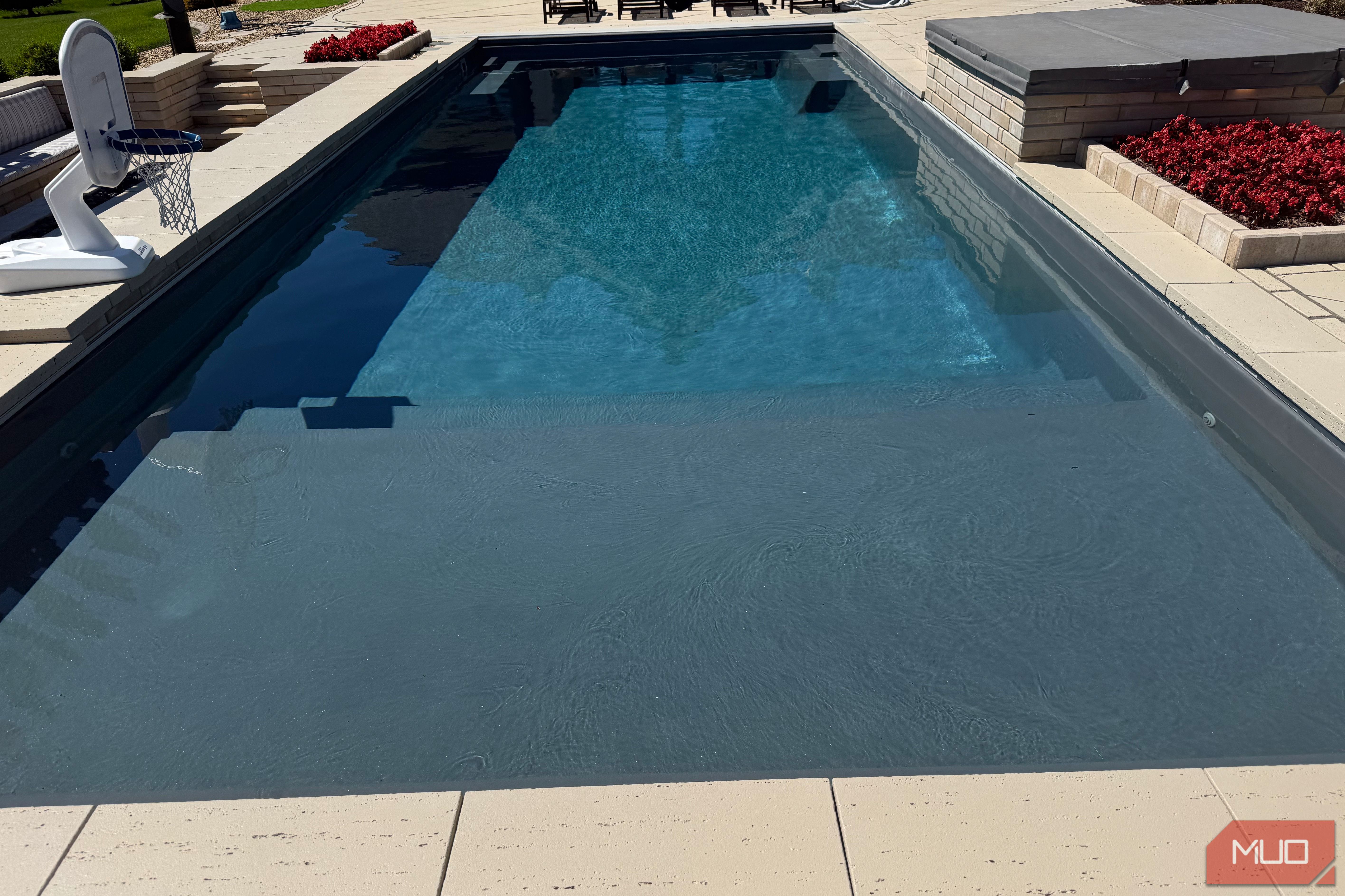 pool with tanning ledge and basketball hoop