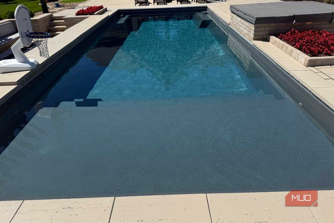 pool with tanning ledge and basketball hoop