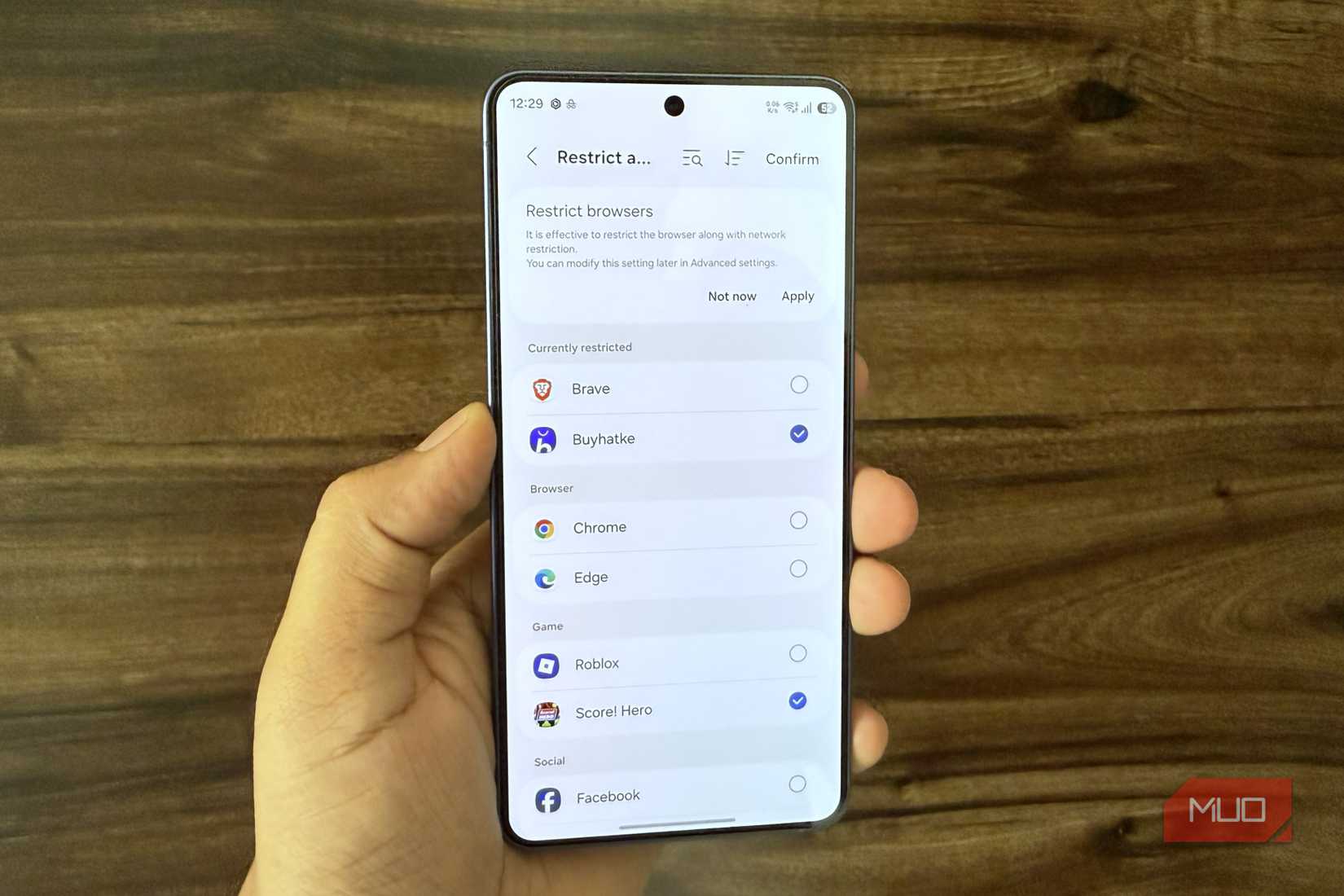 Samsung phone in hand showing Restrict network for specific apps