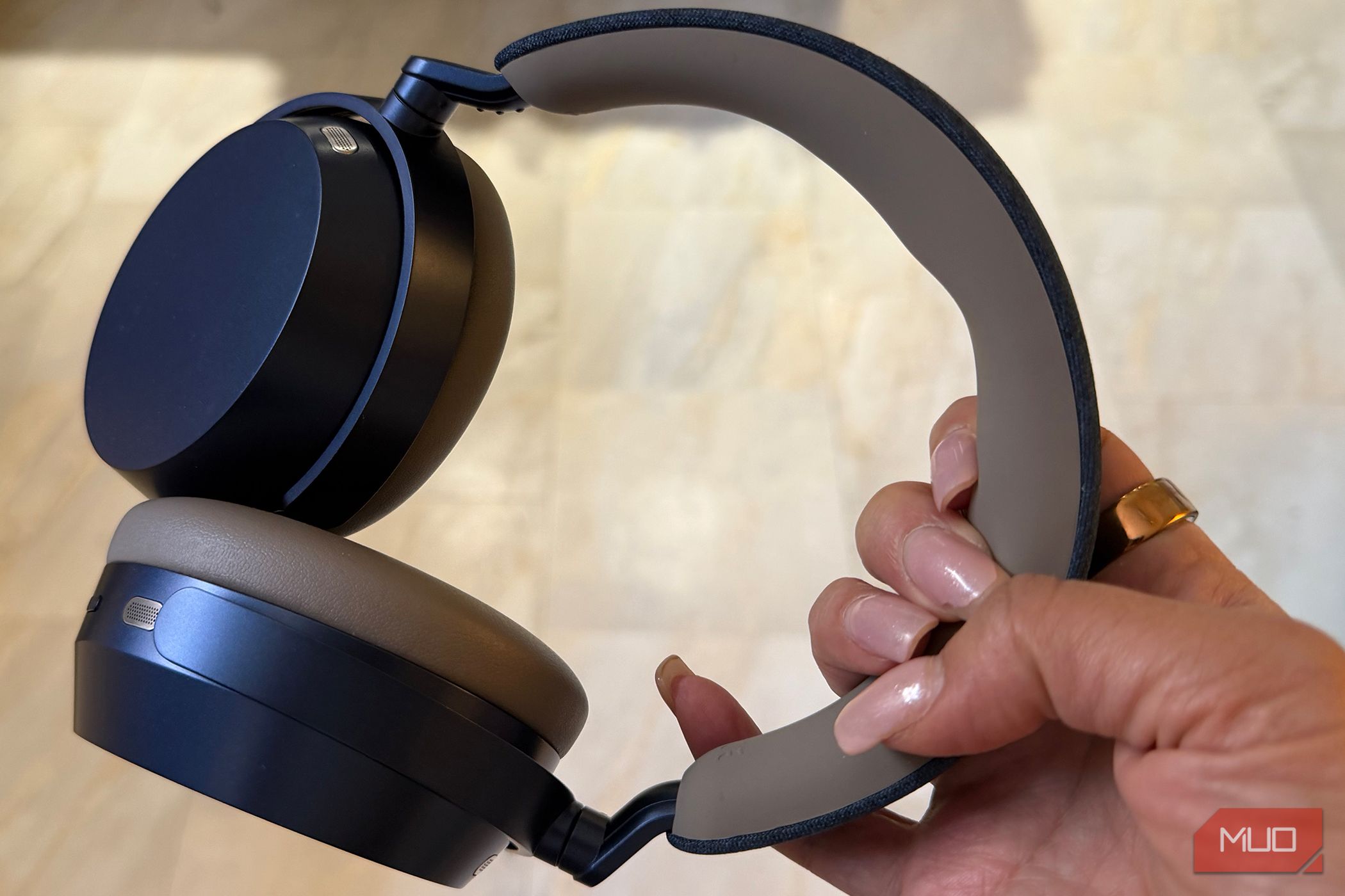 The Sennheiser Momentum 5 headphones held in hand.