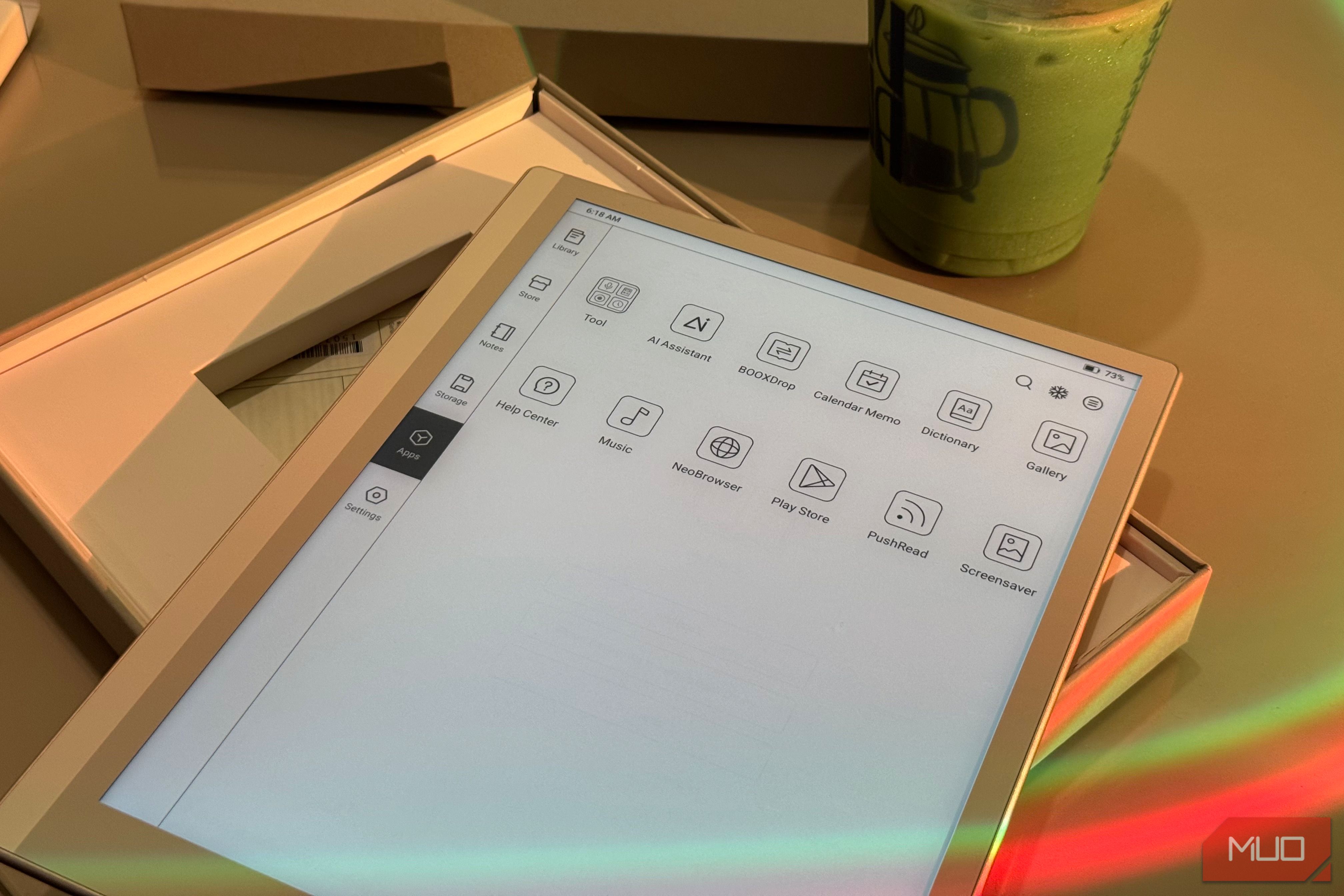 tablet device displaying app menu icons on desk with beverage