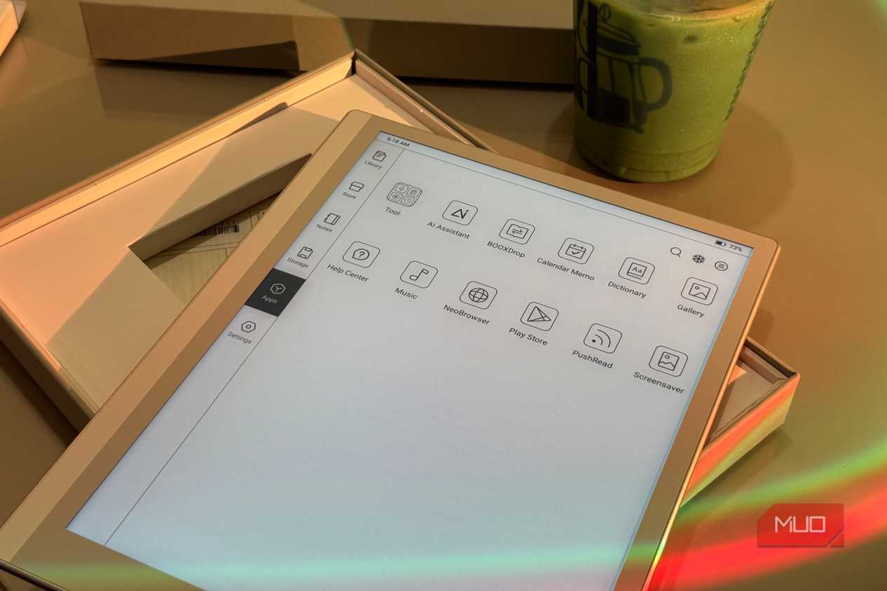 tablet device displaying app menu icons on desk with beverage