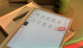 tablet device displaying app menu icons on desk with beverage