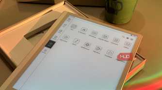 tablet device displaying app menu icons on desk with beverage