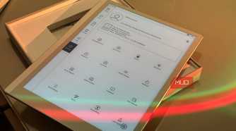 tablet device displaying app menu with various icons and options in wooden holder with colored light reflection