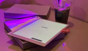 tablet displaying hello text on desk with purple lighting and beverage cup