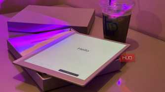 tablet displaying hello text on desk with purple lighting and beverage cup