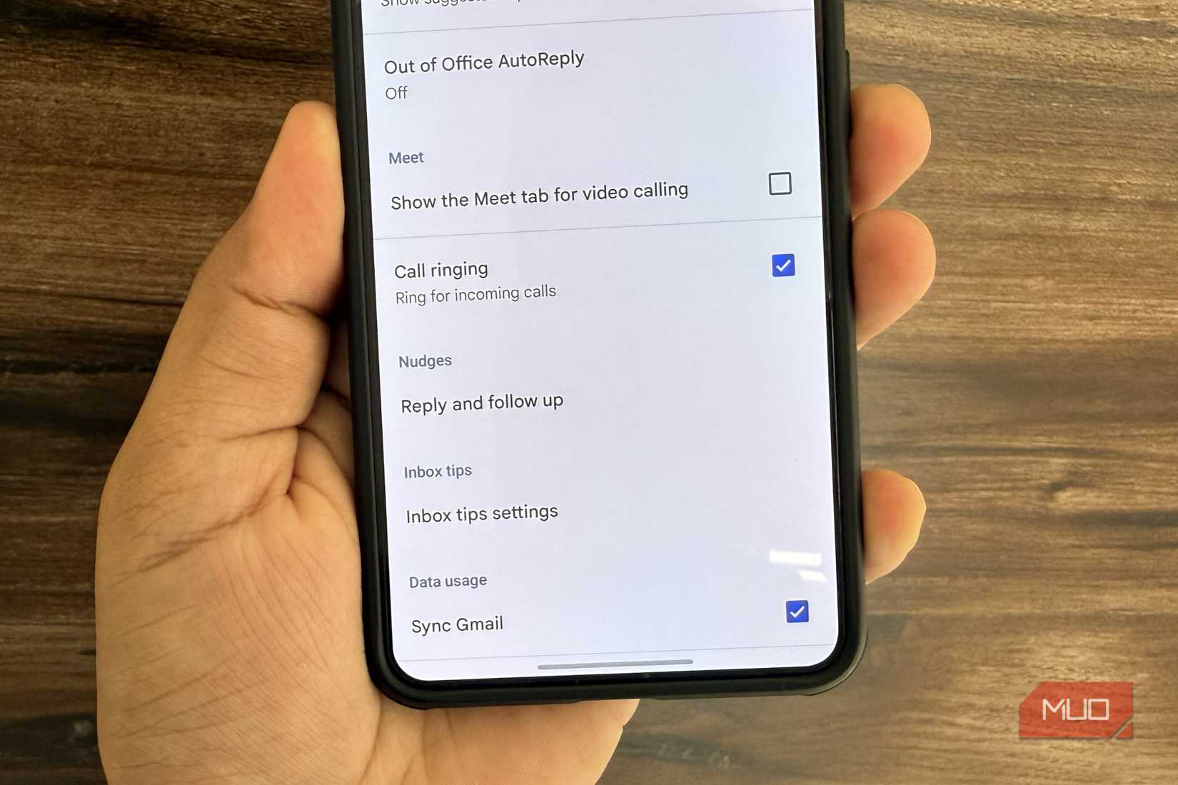 Android phone in hand showing Gmail settings menu