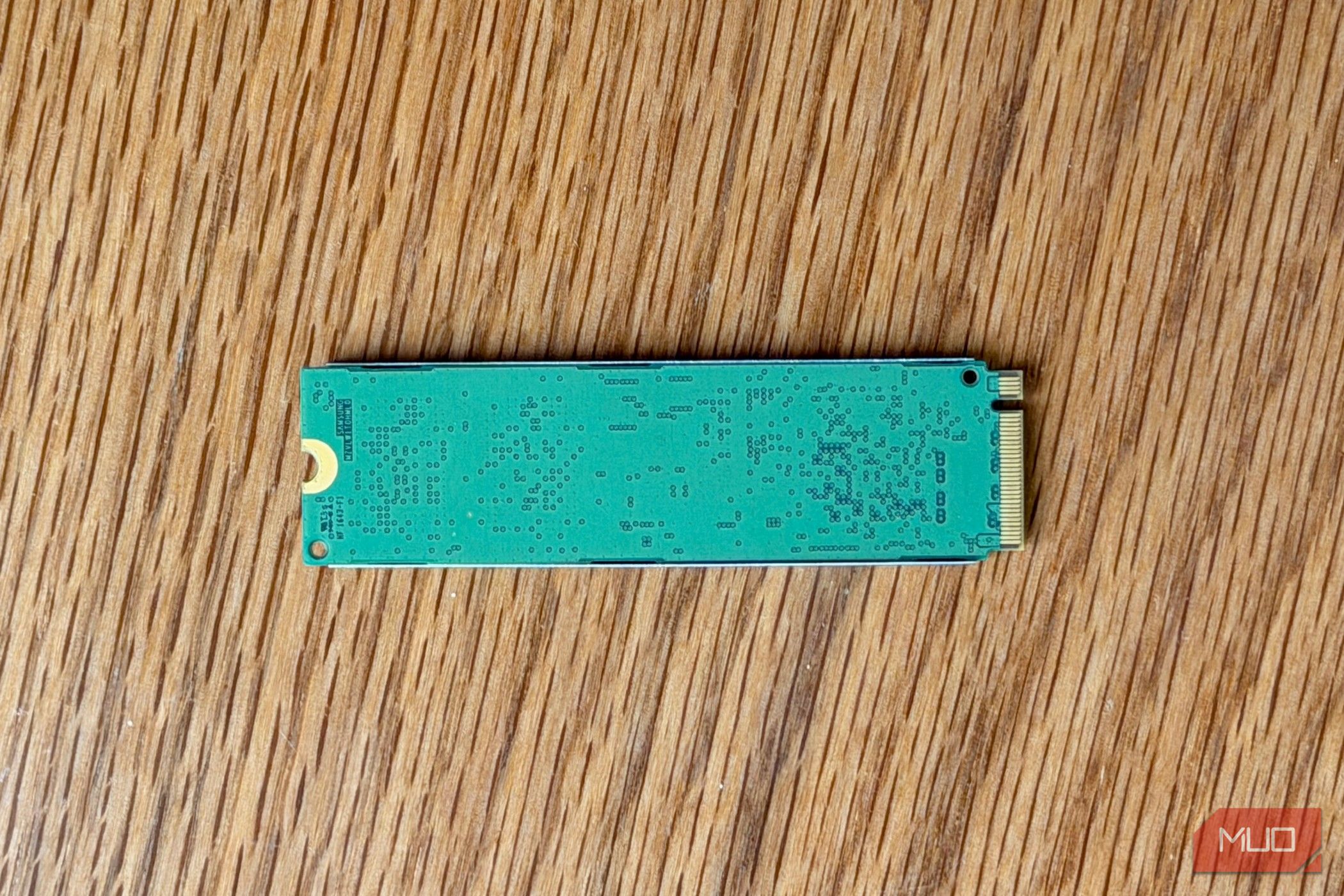 Back of an M.2 NVMe SSD circuit board on a wooden desk