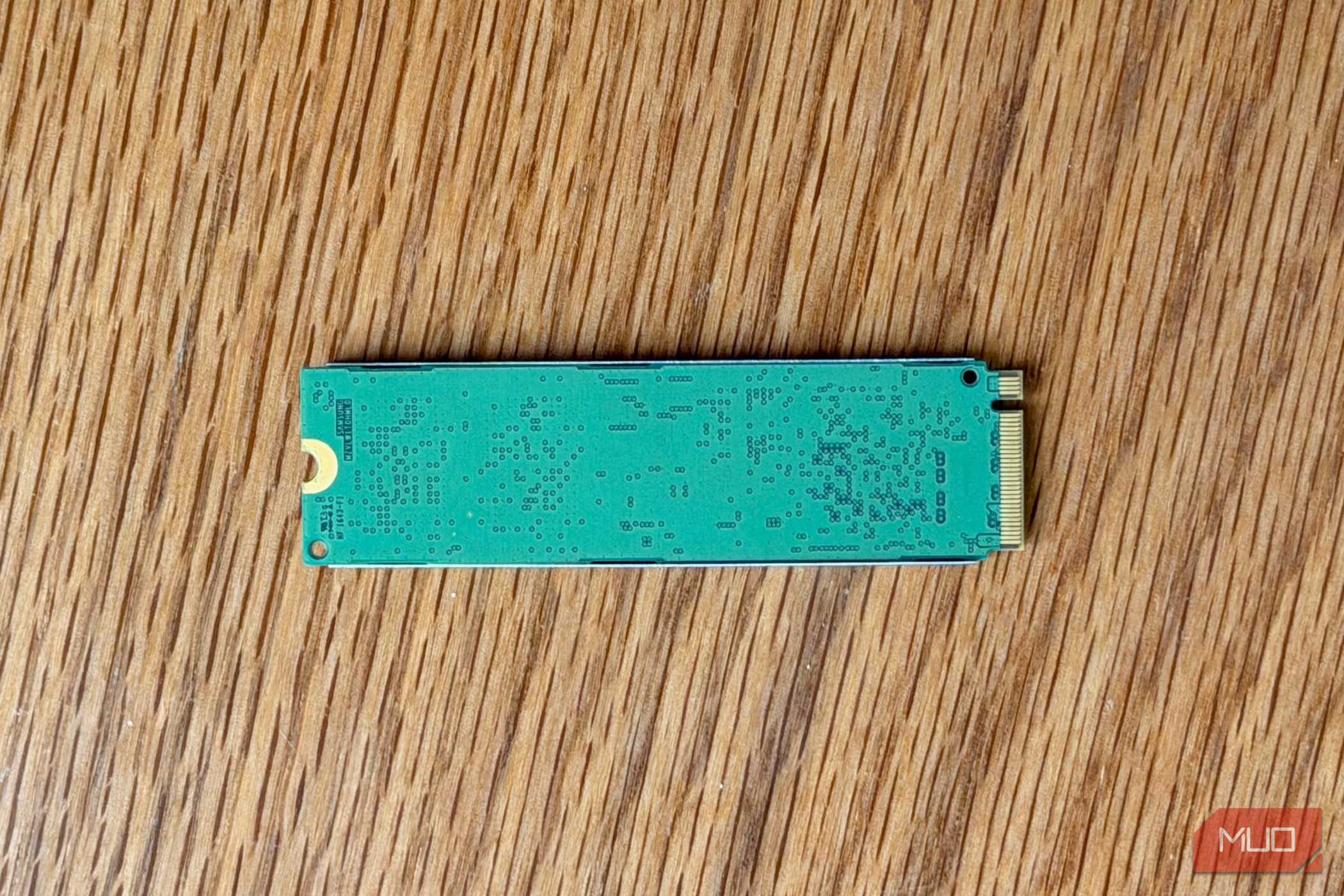 Back of an M.2 NVMe SSD circuit board on a wooden desk