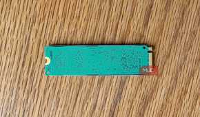 Back of an M.2 NVMe SSD circuit board on a wooden desk