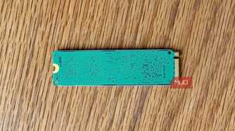 Back of an M.2 NVMe SSD circuit board on a wooden desk