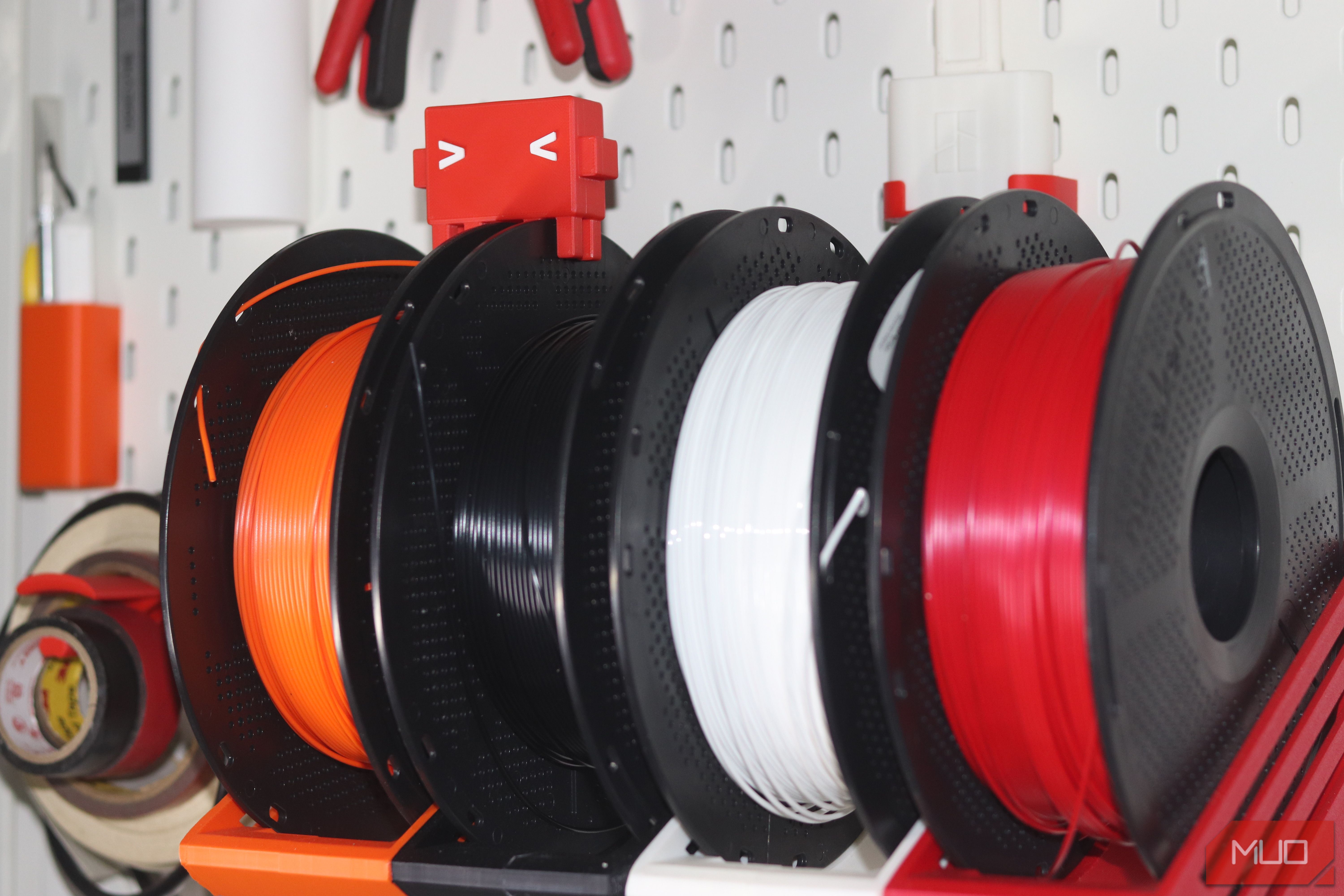 Claude Code mascot and filament spools on a pegboard.