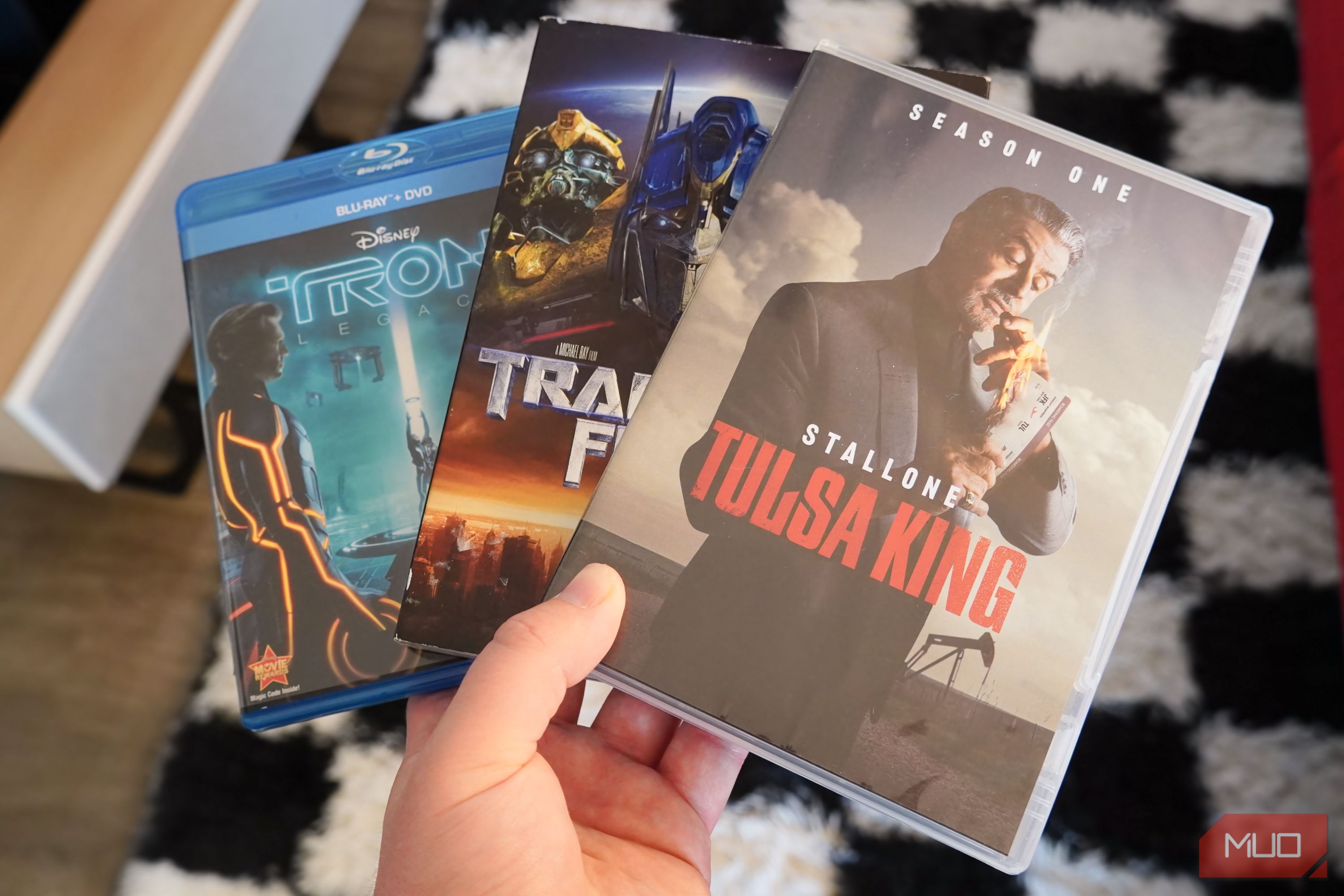 Blu-ray discs and DVDs in the hand.
