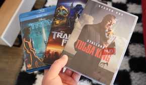 Blu-ray discs and DVDs in the hand.